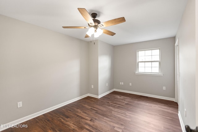 empty room with ceiling fan, dark wood finished floors, visible vents, and baseboards