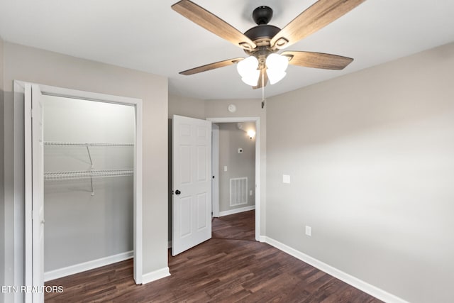 unfurnished bedroom featuring ceiling fan, a closet, dark wood finished floors, and baseboards