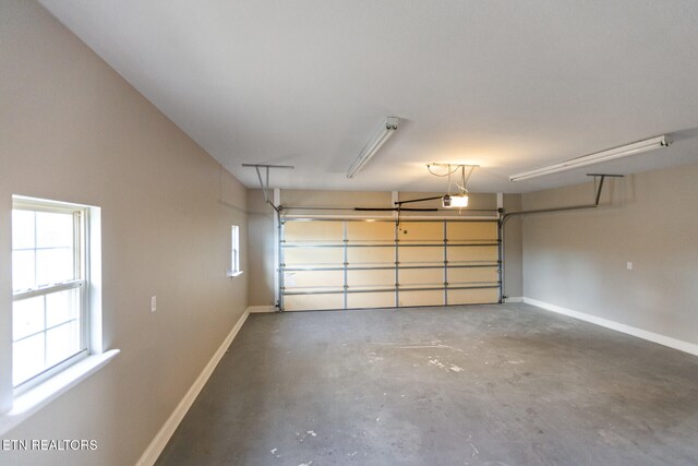 garage with a garage door opener and baseboards