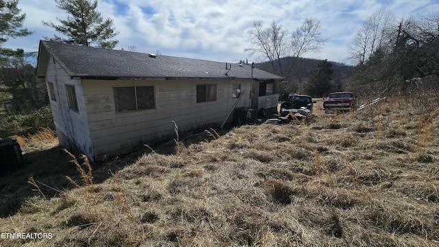 view of property exterior featuring a shingled roof