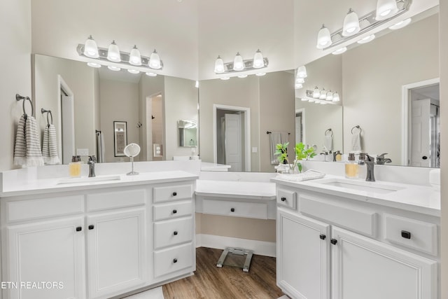 bathroom with wood finished floors, two vanities, and a sink