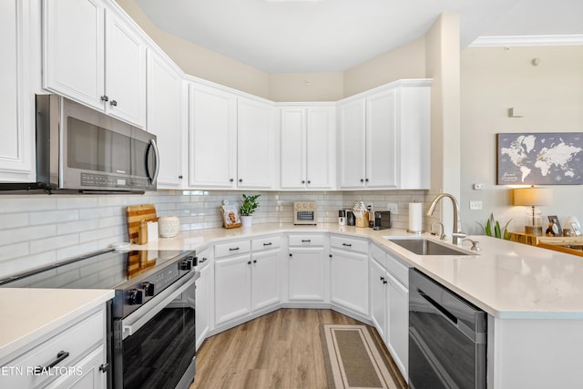 kitchen with electric stove, stainless steel microwave, a sink, dishwasher, and a peninsula