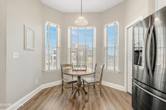 dining area featuring a wealth of natural light, light wood-type flooring, and baseboards