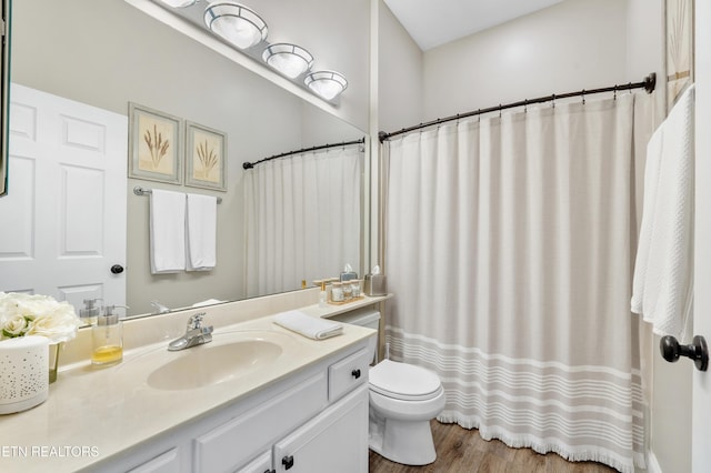 full bathroom with toilet, wood finished floors, and vanity