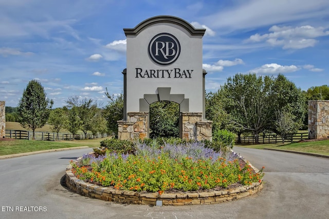 community sign featuring driveway and fence