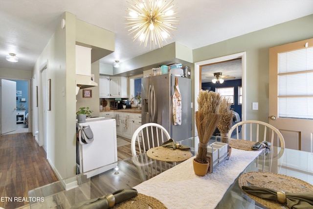 kitchen featuring white cabinets, an inviting chandelier, stainless steel refrigerator with ice dispenser, and wood finished floors