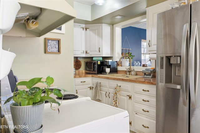 kitchen with white cabinets, stainless steel refrigerator with ice dispenser, a sink, and light countertops