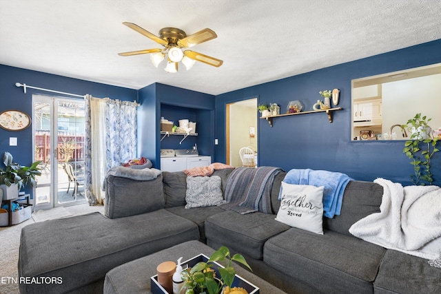 living area with carpet, ceiling fan, a textured ceiling, and independent washer and dryer