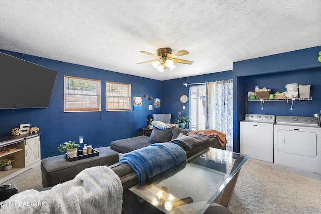 carpeted living area with a ceiling fan, washing machine and dryer, and a textured ceiling