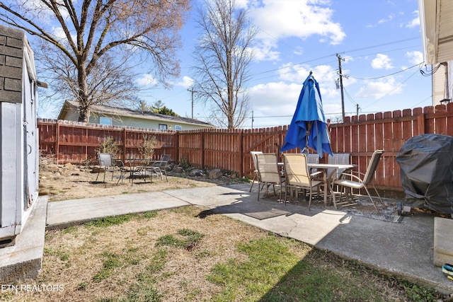 view of yard featuring a fire pit, outdoor dining space, a patio area, and a fenced backyard