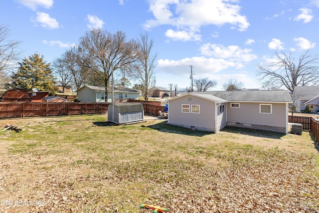 back of property with crawl space, a fenced backyard, central AC, and a yard