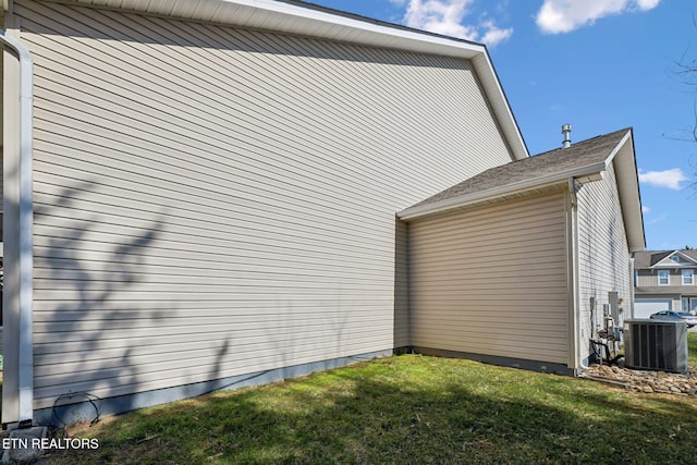 view of side of home featuring cooling unit and a lawn