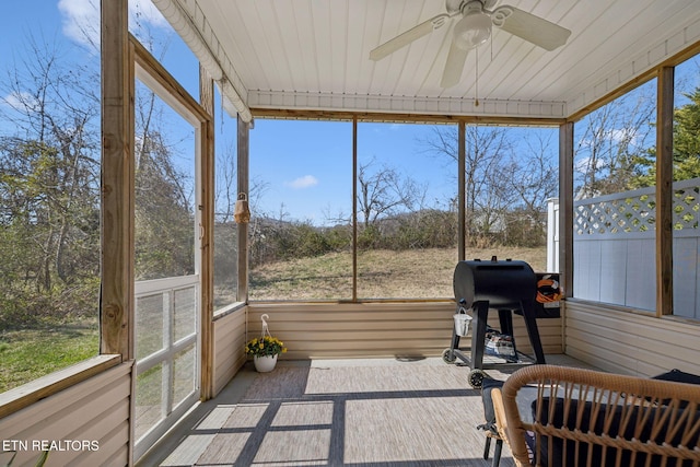 sunroom / solarium featuring a healthy amount of sunlight and ceiling fan