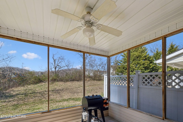 unfurnished sunroom with a wealth of natural light and a ceiling fan