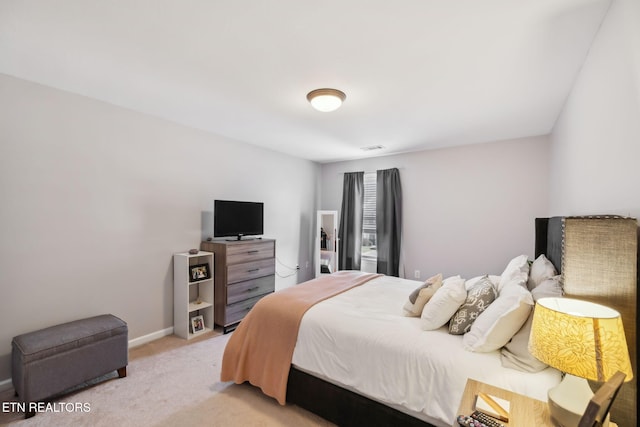 bedroom featuring visible vents, light carpet, and baseboards