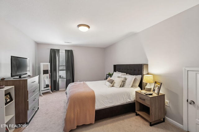 bedroom with visible vents, light colored carpet, and baseboards