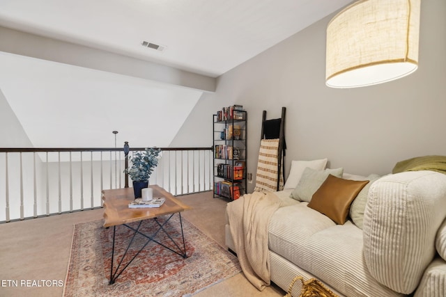 living area with visible vents, lofted ceiling, and carpet