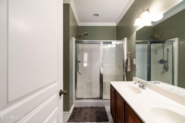 bathroom with a stall shower, crown molding, and a sink