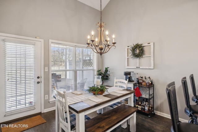 dining room featuring baseboards, dark wood-style flooring, a wealth of natural light, and a chandelier