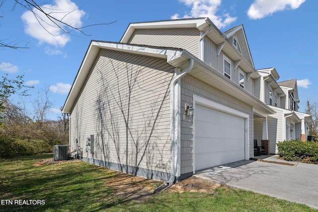 view of property exterior featuring cooling unit, an attached garage, driveway, and a yard