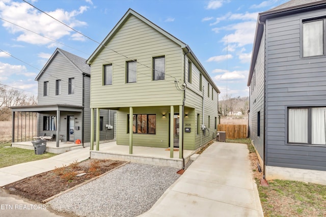 view of front of home with a porch, central AC, and fence