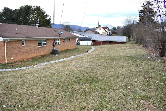 view of yard with fence and central AC unit