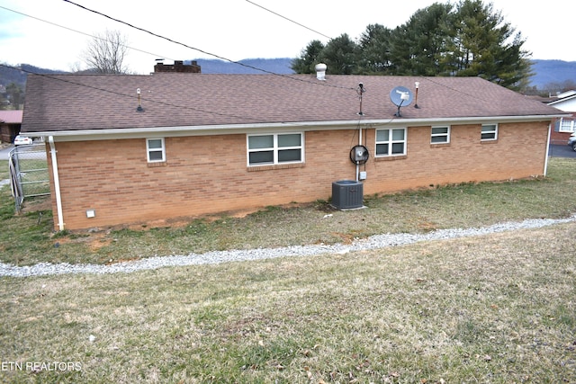 view of side of property featuring brick siding, a chimney, and roof with shingles