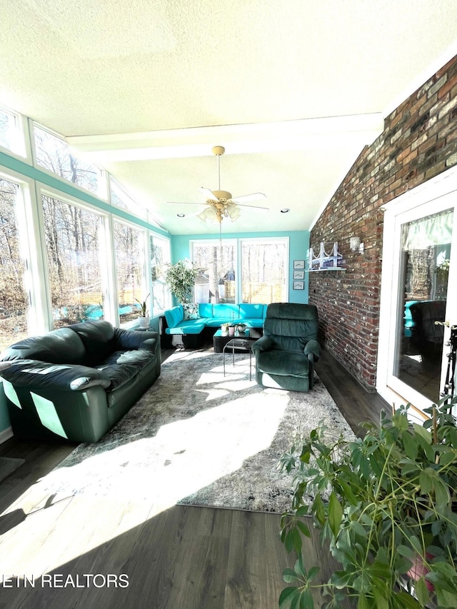 sunroom featuring lofted ceiling with beams and ceiling fan