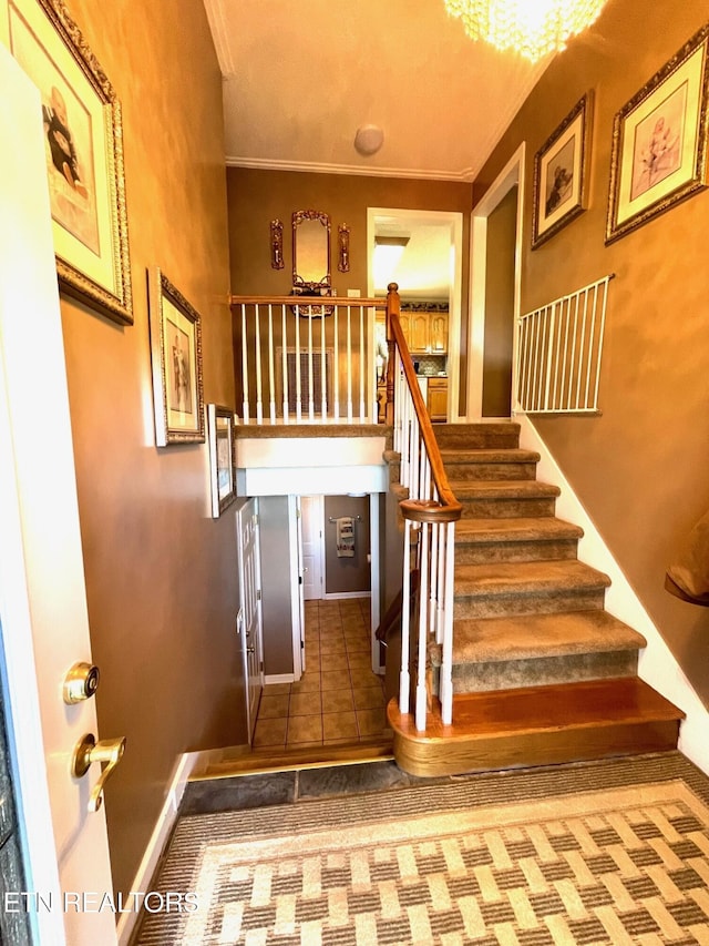 staircase featuring tile patterned floors, baseboards, and crown molding