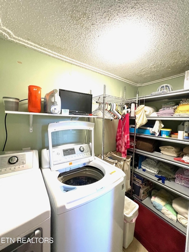 laundry area featuring washer and dryer, laundry area, and a textured ceiling