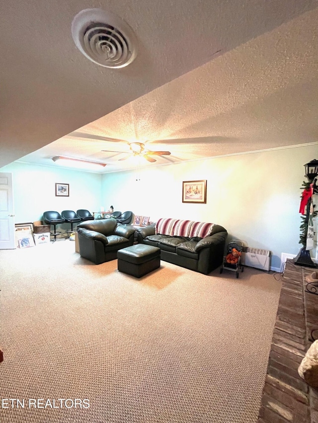 carpeted living room featuring ceiling fan, visible vents, and a textured ceiling