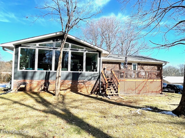 rear view of property with a wooden deck, stairs, and a sunroom