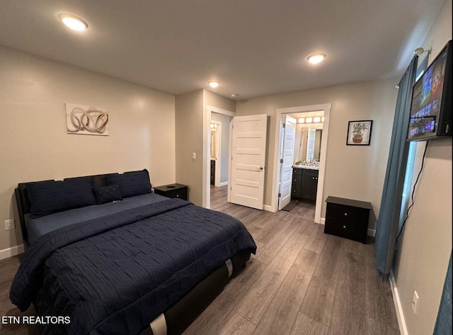 bedroom with ensuite bath, baseboards, dark wood finished floors, and recessed lighting