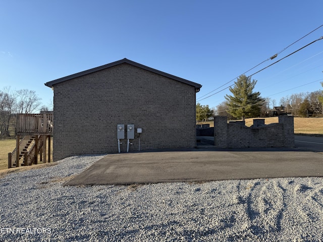 view of side of property with brick siding and stairway