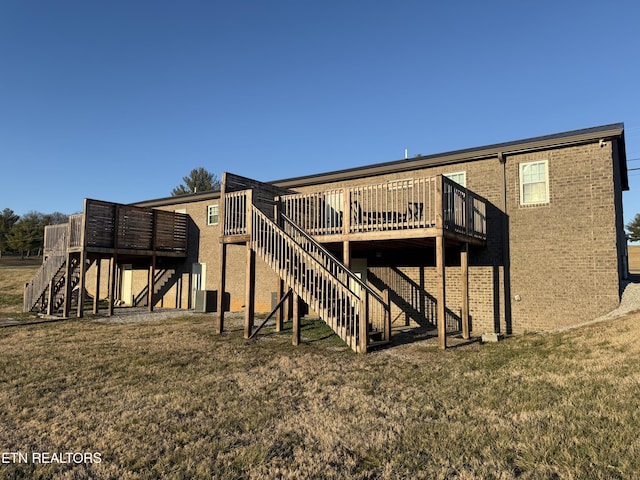 back of house with a deck, stairway, and a lawn