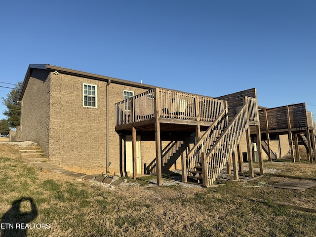 rear view of property featuring stairs and a deck