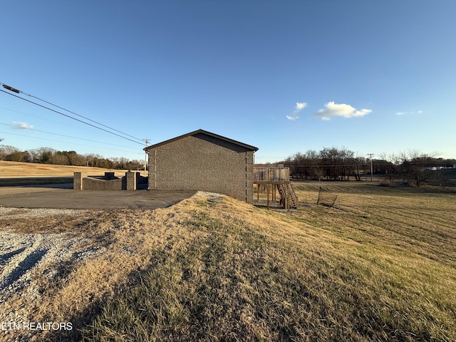 view of side of home featuring a rural view and a yard