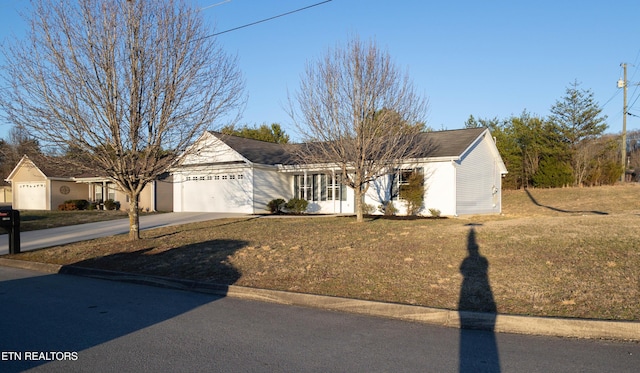 ranch-style house with a garage, driveway, and a front lawn