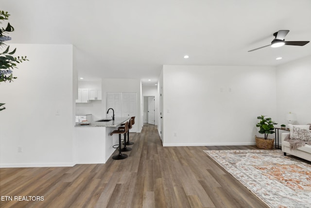 living room featuring ceiling fan, recessed lighting, wood finished floors, and baseboards