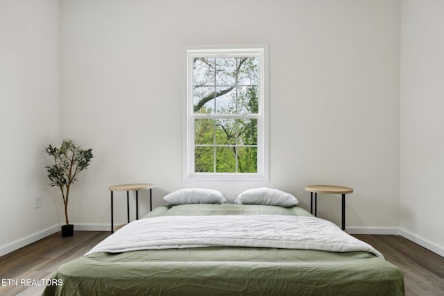 bedroom with wood finished floors and baseboards