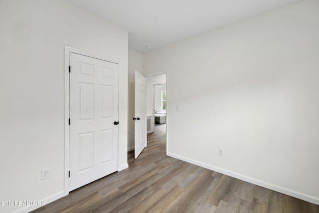 unfurnished bedroom with baseboards and wood finished floors
