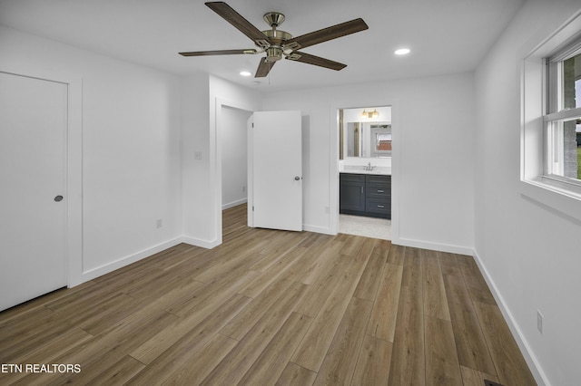 unfurnished bedroom with light wood-type flooring, baseboards, connected bathroom, and recessed lighting