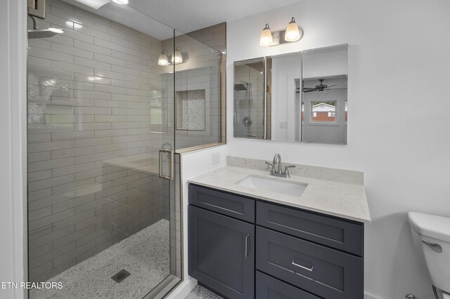 full bath featuring toilet, a shower stall, ceiling fan, and vanity