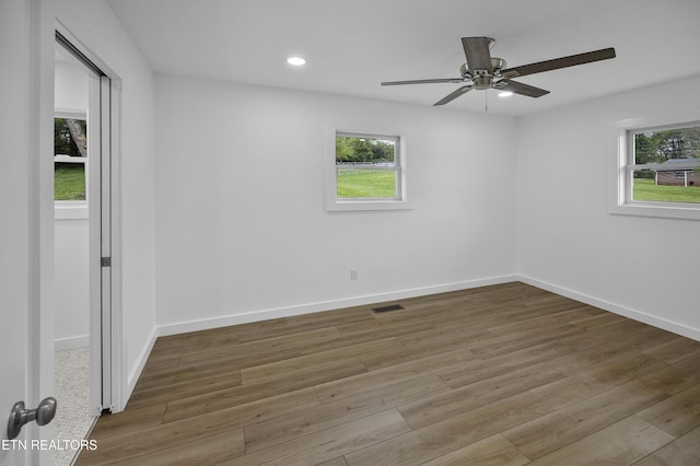 unfurnished room featuring baseboards, wood finished floors, visible vents, and recessed lighting