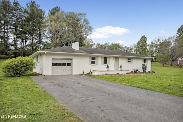 single story home featuring aphalt driveway, brick siding, a chimney, a garage, and a front lawn