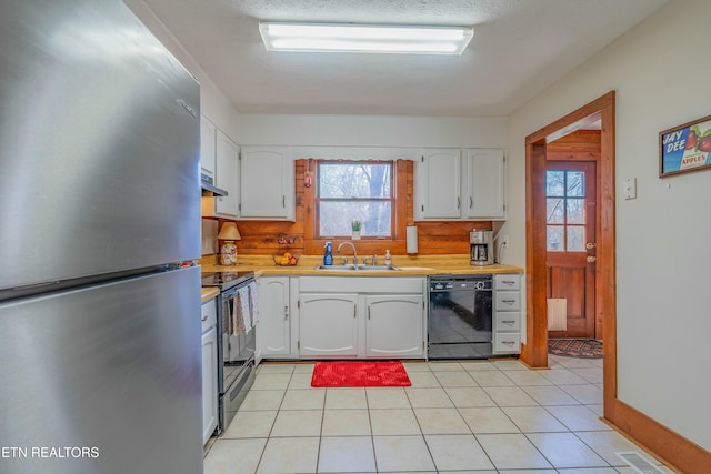 kitchen with white cabinets, black appliances, light countertops, and a sink