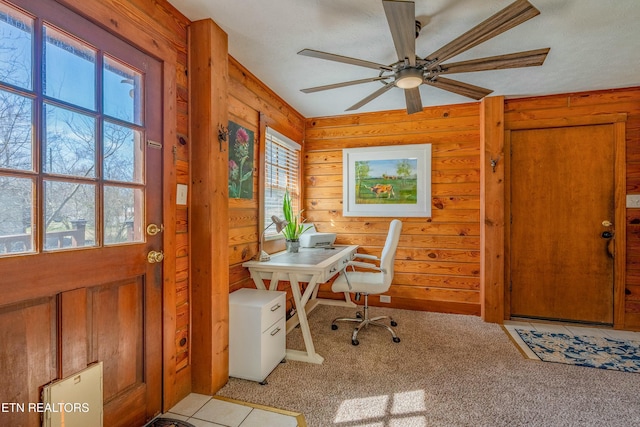 carpeted office featuring ceiling fan and wooden walls