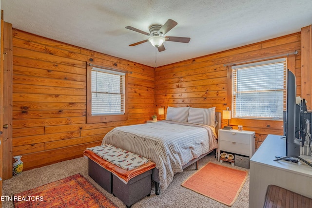 bedroom featuring a textured ceiling, multiple windows, and light carpet