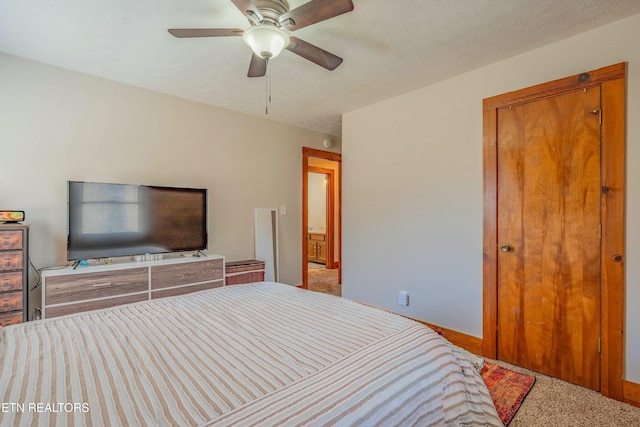 carpeted bedroom with a ceiling fan and a textured ceiling