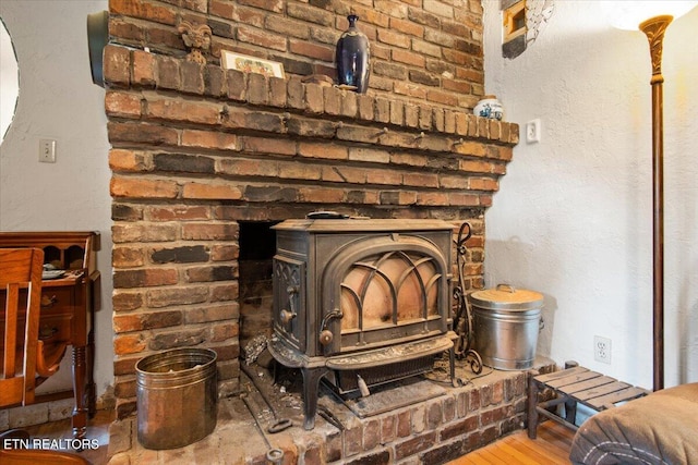 room details featuring a wood stove and wood finished floors